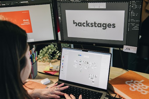 Femme sur son ordinateur avec le logo Backstages en fond
